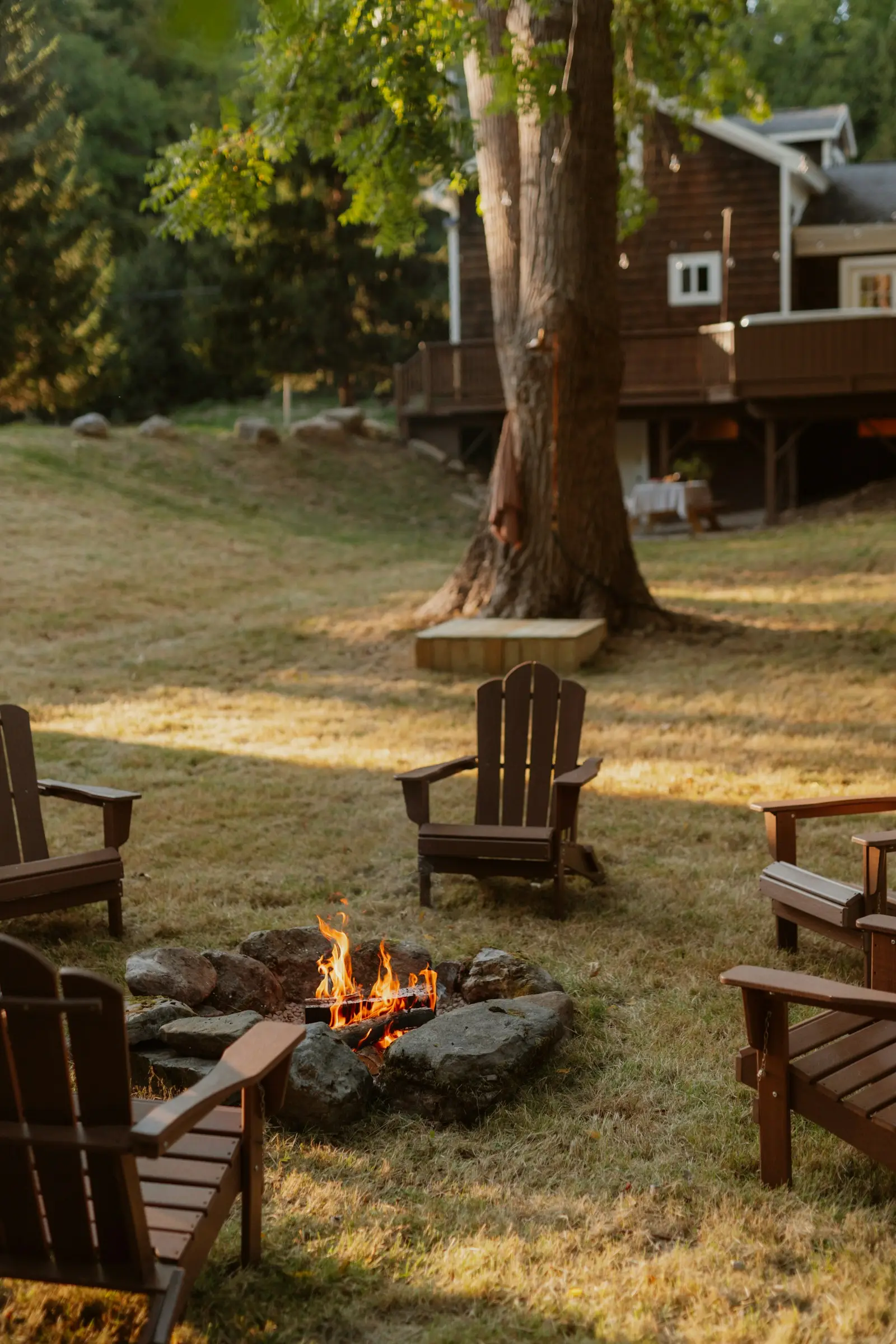 Reference: stone-rimmed backyard fire pit ringed with adirondack chairs