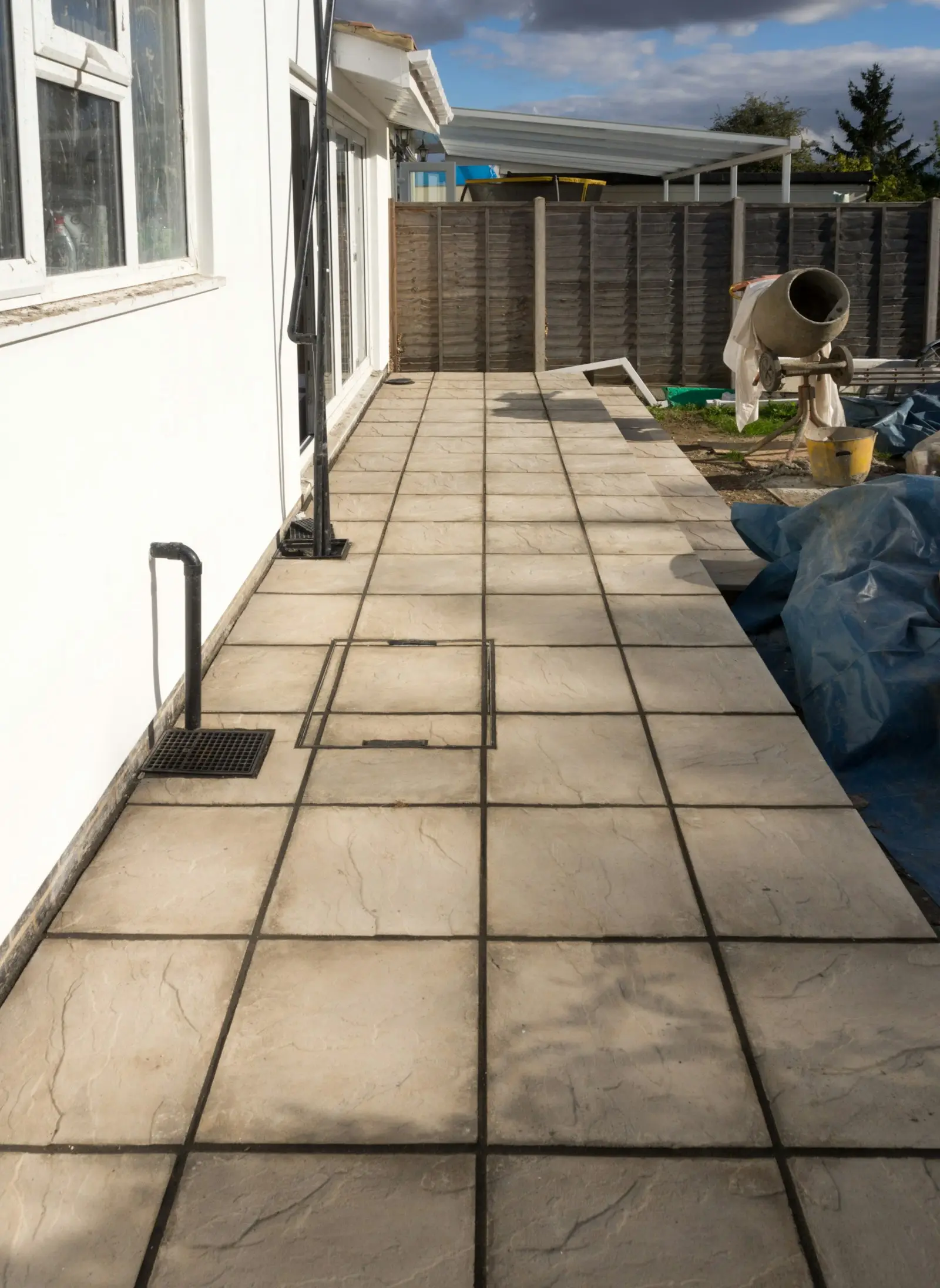 Reference: stamped-pattern paver patio installed alongside a residential exterior